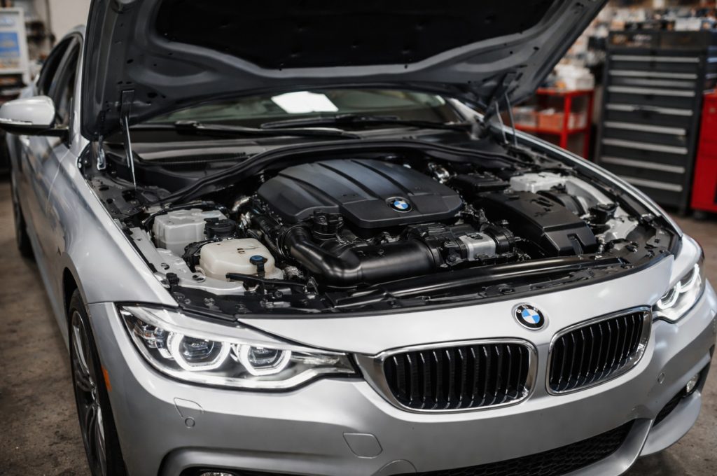 silver BMW with hood open so our mechanics can start to diagnose the engine issue